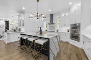 Image of white kitchen with marble countertops.