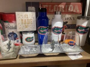 Florida Gator cups and water bottles placed on a shelf.